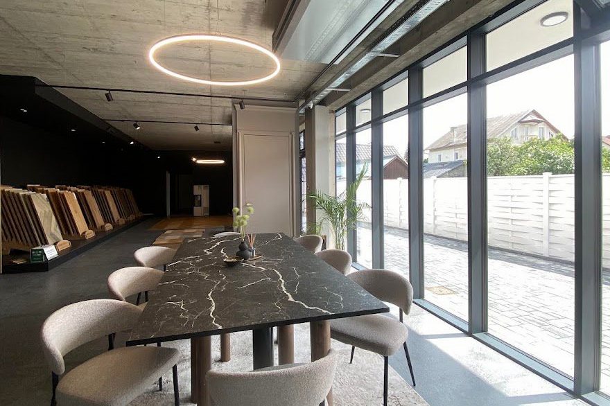 Masă de consultanță din piatră, cu mostre de finisaje pe perete, în showroomul Gioia Casa